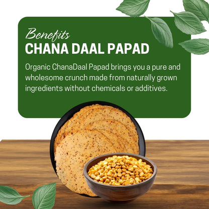 Chana Daal Papad with a bowl of chana, on a wooden surface, surrounded by green leaves.